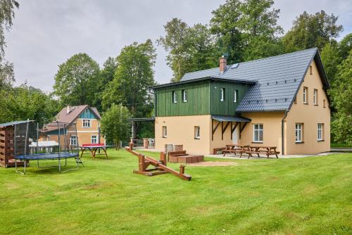 a large house with a playground in the yard at Apartmány Rudník Bolkov in Rudník