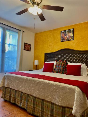 a bedroom with a large bed with a ceiling fan at Hotel la Galería in Antigua Guatemala