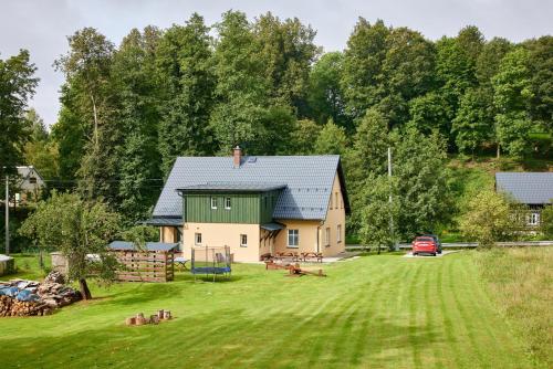 a house with a green roof and a yard at Apartmány Rudník Bolkov in Rudník