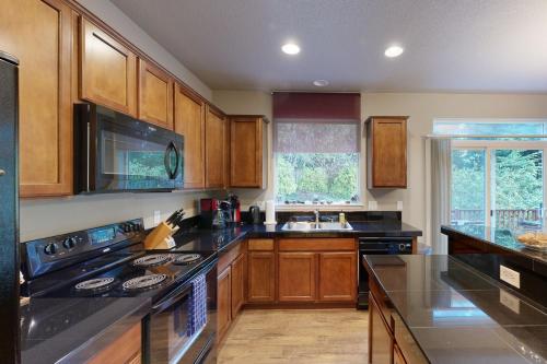a kitchen with wooden cabinets and black counter tops at Sundown Lagoon in Tillamook