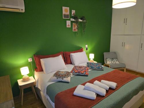 a green bedroom with a bed with towels on it at Charming Vólos House 2 in Volos