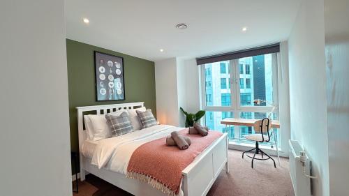 a bedroom with a bed and a desk and a window at Shoreditch Britannia Apartments in London