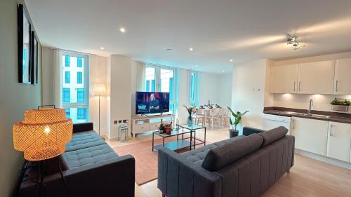 a living room with a couch and a kitchen at Shoreditch Britannia Apartments in London