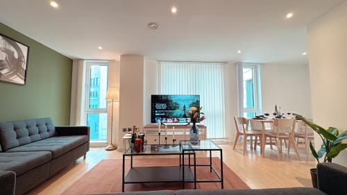 a living room with a couch and a table at Shoreditch Britannia Apartments in London
