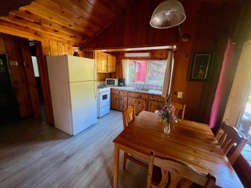 a kitchen with a wooden table and a white refrigerator at Fern River Resort in Felton