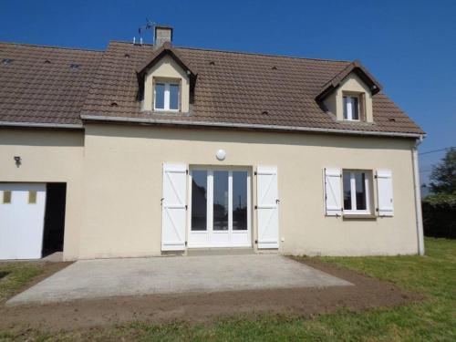 a white house with white doors and a roof at Maison avec terrain clos in Denneville-Plage