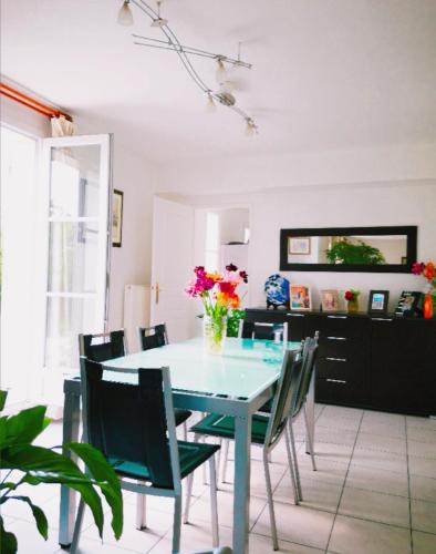 une table à manger avec des chaises et un vase de fleurs. dans l'établissement 玫瑰花苑, à Bussy-Saint-Georges