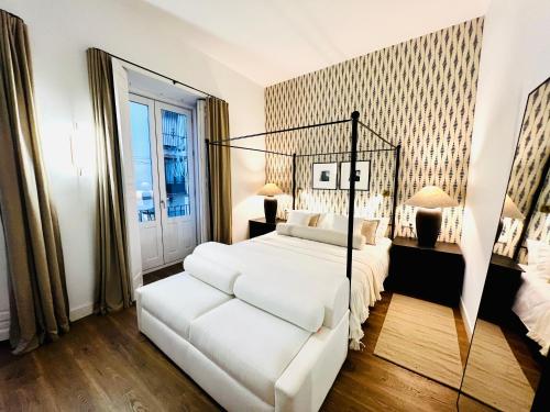 ベレス・マラガにあるPUERTA de la AXARQUIA HOTEL BOUTIQUEの白いベッドルーム(ベッド1台、大きな鏡付)