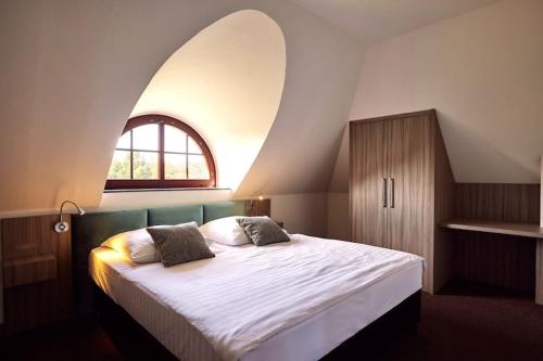 una camera da letto con un letto grande con una finestra di Ferienhaus im Van der Valk Resort in Linstow a Dobbin-Linstow