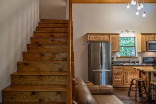 a staircase in a kitchen with a stainless steel refrigerator at Secluded cabin convenient to Blairsville in Blairsville