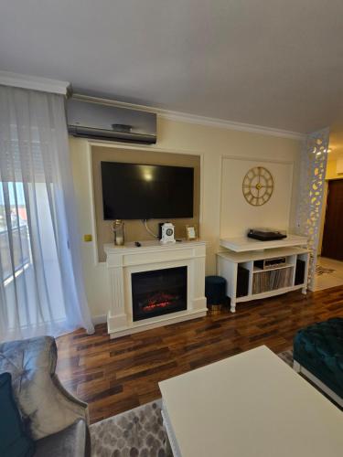a living room with a fireplace and a flat screen tv at Apartman DADO in Modriča