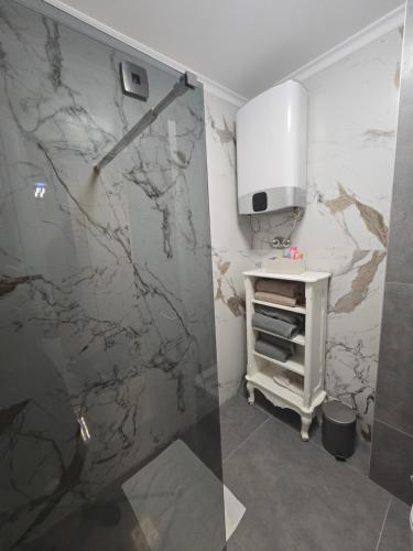 a bathroom with a marble shower curtain and a sink at Apartman DADO in Modriča