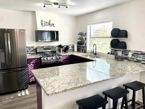 a kitchen with purple cabinets and a stainless steel refrigerator at Super Comfy Home with Hot Tub! in Round Rock