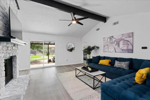 a living room with a blue couch and a fireplace at Super Comfy Home with Hot Tub! in Round Rock