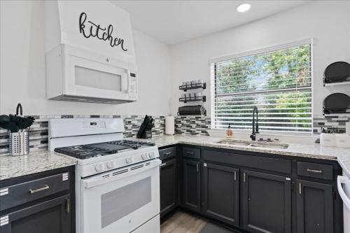 a kitchen with a white stove top oven next to a window at Super Comfy Home with Hot Tub! in Round Rock