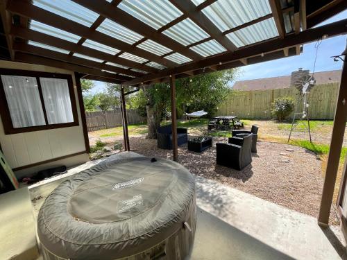 an outdoor patio with a cover and a fire pit at Super Comfy Home with Hot Tub! in Round Rock