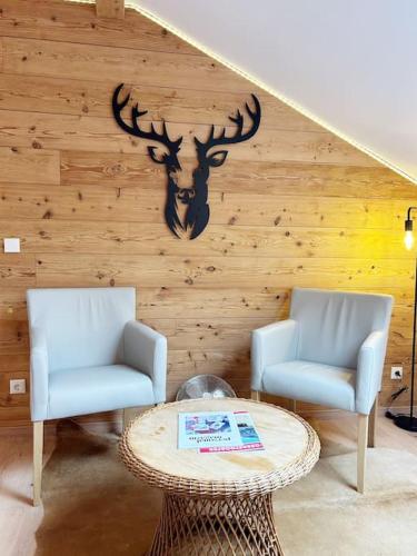 two chairs and a table in a room at FEWO Allgäu Chalet mit Schwimmbad und Sauna in Oberstdorf