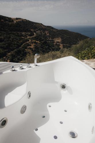 a white bath tub with a view of the ocean at Lefteris Rooms in Kámbos