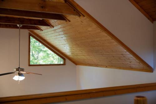 an attic with a window and a ceiling fan at Secluded cabin convenient to Blairsville in Blairsville