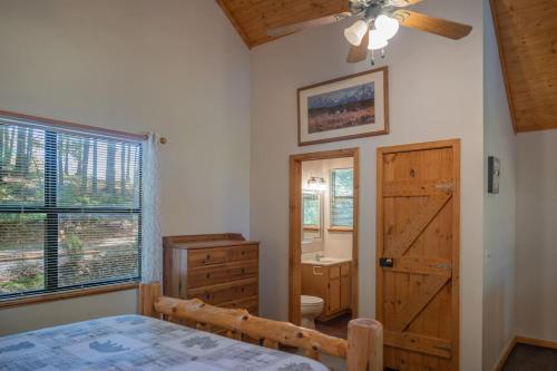 a bedroom with a bed and a dresser and a bathroom at Secluded cabin convenient to Blairsville in Blairsville