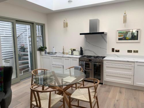 a kitchen with a glass table and a stove at Village 3 bed Town House in Dublin