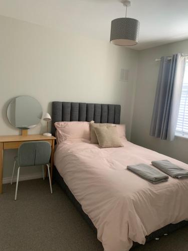 a bedroom with a bed with a desk and a chair at Village 3 bed Town House in Dublin