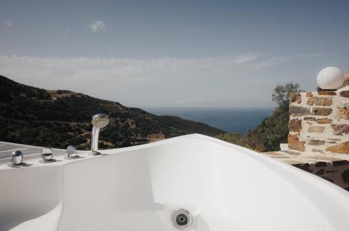 a white bathroom sink with a view of the ocean at Lefteris Rooms in Kámbos