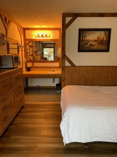 a bedroom with a bed and a dresser and a mirror at Beverly Hills Inn in Aberdeen