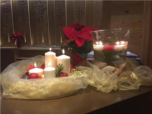 a table with candles and strawberries and a vase with lights at Hotel Nigritella in Selva di Cadore