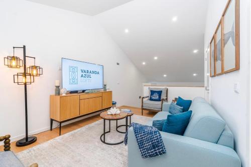 a living room with a blue couch and a tv at Varanda Azul - Lookout Loft (City Centre) in Ponta Delgada