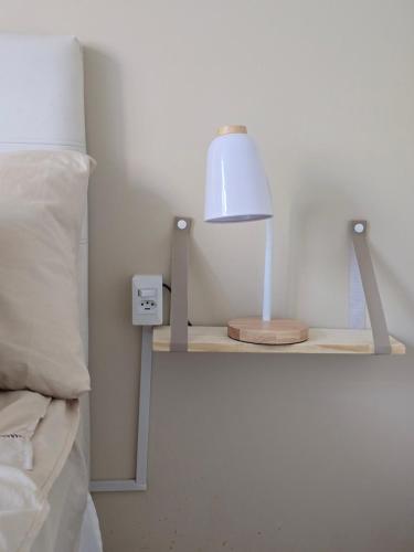 a lamp on a shelf next to a bed at apartment cool & seafront Arpoador in Rio de Janeiro