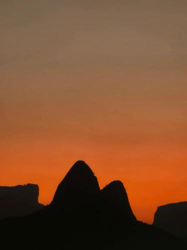 a silhouette of the mountains at sunset at apartment cool & seafront Arpoador in Rio de Janeiro