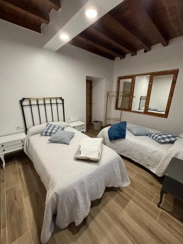 two beds in a room with two mirrors at Casa Rural CEPA ALTA DEL HOCILLO in Zamora