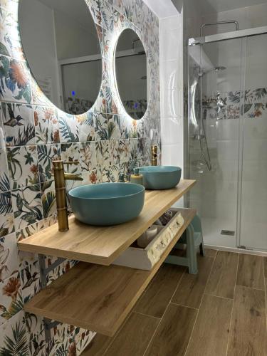 a bathroom with two blue sinks and a mirror at Casa Rural CEPA ALTA DEL HOCILLO in Zamora