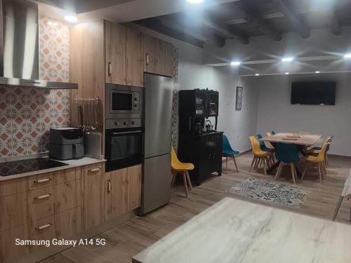 a kitchen with stainless steel appliances and a table with chairs at Casa Rural CEPA ALTA DEL HOCILLO in Zamora