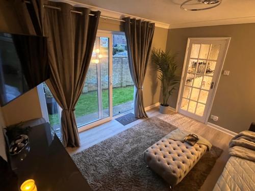 a living room with a couch and a large window at Secluded cosy extension with free parking, sleeps 4 in Blackwater