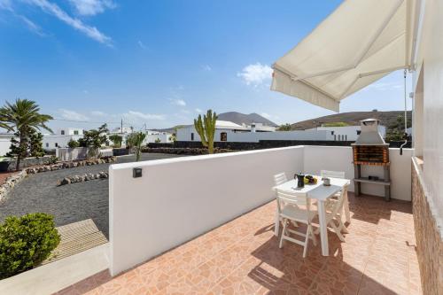 a patio with a white fence and a table and chairs at Casa Carla in La Vegueta