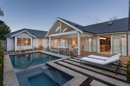 a house with a swimming pool in front of it at Muskoka Luxe Retreat with Pool Spa & Fire Pit in Mount Martha