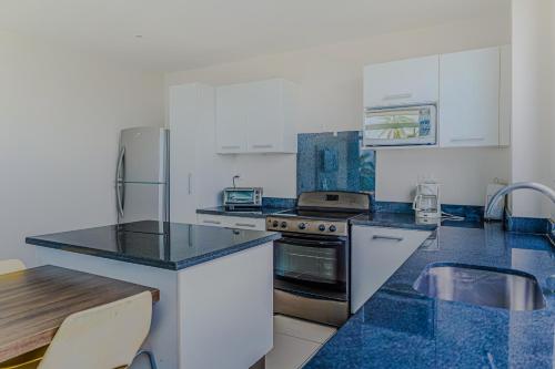 a kitchen with white cabinets and blue granite counter tops at Puerto Azul 138 in El Roble