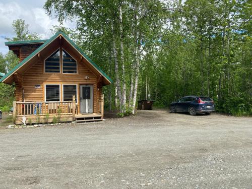 a car parked in front of a log cabin at Talkeetna Log Cabin with Hot Tub Unit 1 in Talkeetna