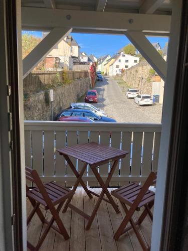 a wooden table and two chairs on a balcony at Neue Unterkunft mit Kamin im Erzgebirge - SZB in Neuanbau