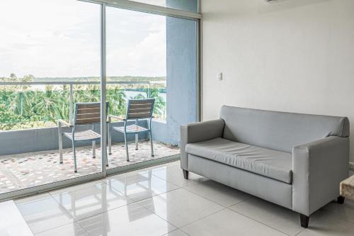 a living room with a couch and two chairs at Puerto Azul 153 in El Roble