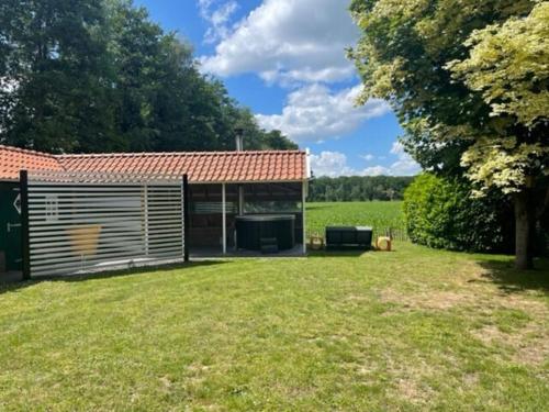 Taman di luar De Goudvink 7-persoons, overdekte hottub en loungebank, finse sauna, wifi, sunshower