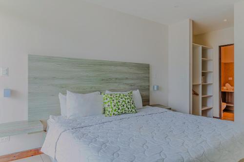 a white bed with two pillows on top of it at Puerto Azul 138 in El Roble
