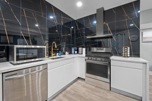 a kitchen with white appliances and black tiles at Modern Studio Retreat with Free Park in Houston