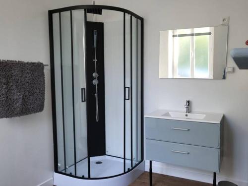 a bathroom with a glass shower and a sink at Charmante maison in Cerisi-Belle-Étoile
