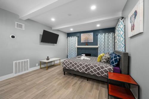 a bedroom with a bed and a tv at Modern Studio Retreat with Free Park in Houston
