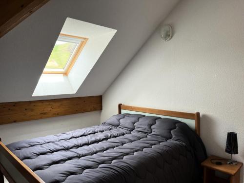 ein Bett in einem Zimmer mit Fenster in der Unterkunft Résidence Balcons Du Soleil 1 - T3/6pers BALCONS DU SOLEIL 63- Peyresourde MAE-9544 in Germ