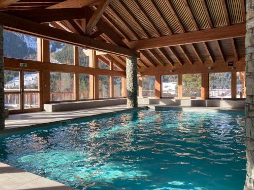 - une piscine dans une maison avec fenêtres dans l'établissement Bel appartement avec piscine, sauna et parkings à Pralognan-la-Vanoise - FR-1-464-217, à Pralognan-la-Vanoise