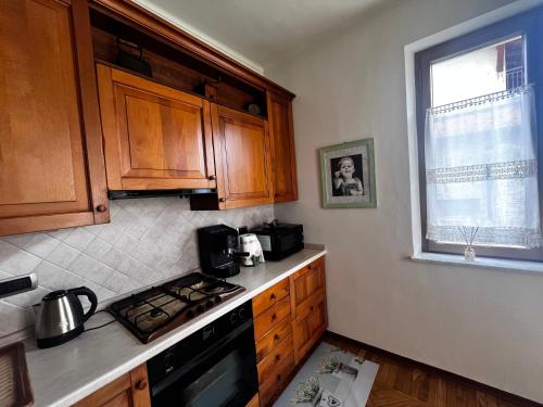 a kitchen with wooden cabinets and a stove top oven at Ca d Rita in Borgo San Dalmazzo